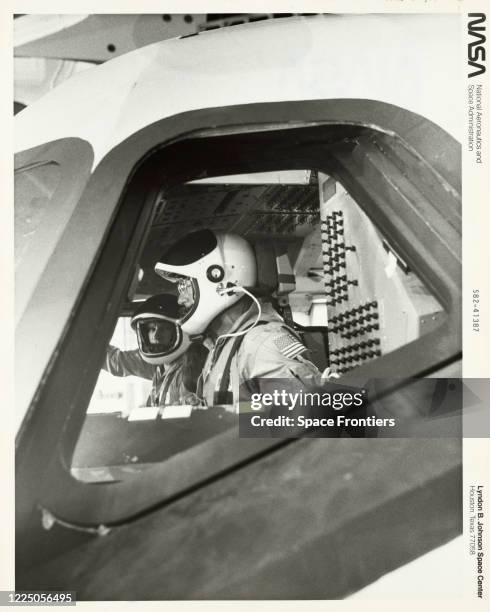 Astronauts Paul J Weitz and Karol J Bobko log some training time in the flight deck of the engineering mockup for the Space Shuttle orbiter...