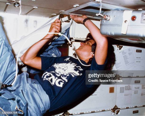 American astronaut and physicist Sally Ride , mission specialist, uses a screwdriver to clean out an air filtering system in the middeck of Space...