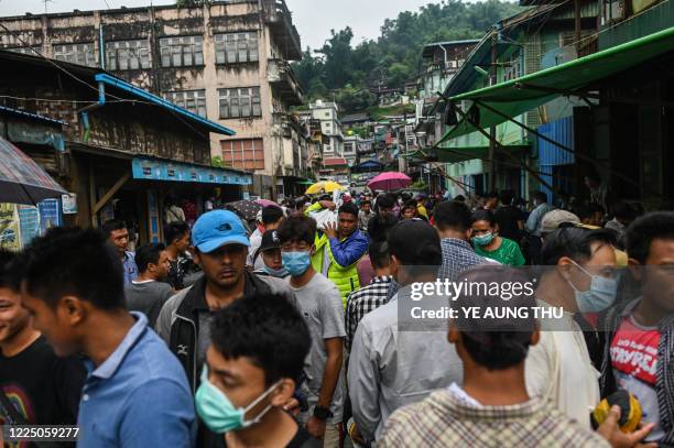 This photo taken on July 6, 2020 shows people walking through a jade market in Hpakant in Kachin state. Myanmar is one of the world's biggest sources...