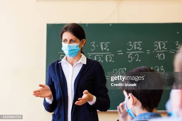 covid-19. a teacher teaches mathematics - teacher covid stock pictures, royalty-free photos & images