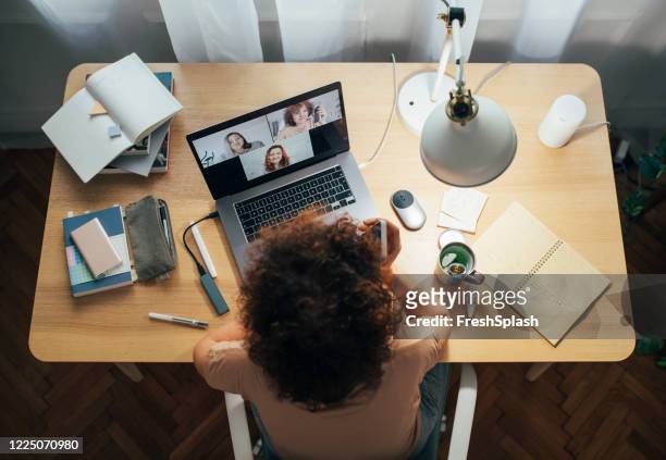 soziale entsagung und selbstfürsorge: glückliche frau telekonferenzen von zu hause aus - working from home stock-fotos und bilder