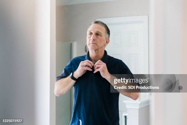 in morning, mature man prepares for his work day - buttoning stock pictures, royalty-free photos & images