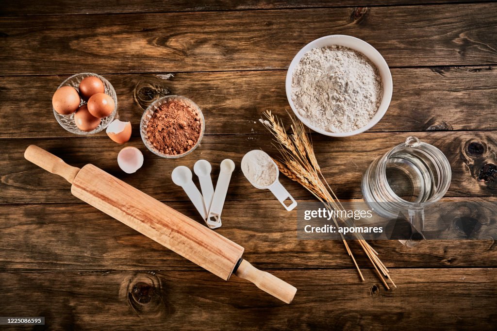 Gluten free bread ingredients and utensils on wood frame background