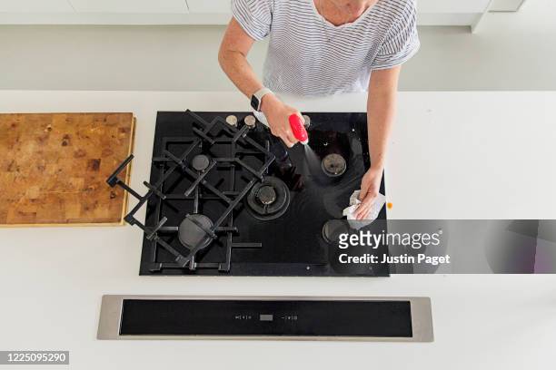 overhead view of a woman cleaning her gas hob - piano del fornello foto e immagini stock