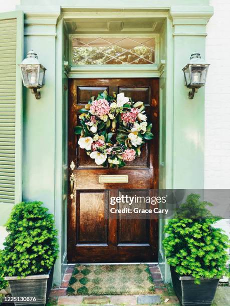 stained wood door with green trim - fussmatte vor haustür stock-fotos und bilder