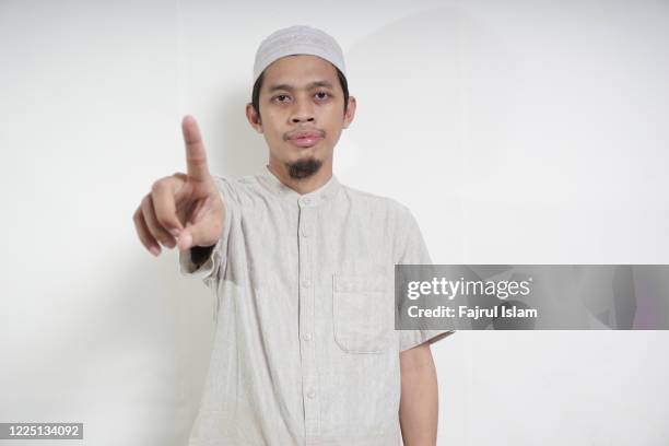 portrait of asian muslim young man - prayer pose greeting stock-fotos und bilder