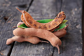 fresh sweet ripe tamarind with leaf,selective focus, healthy fruit,tamarind fruits and green leaves on red bowl,organic tamarind nature,