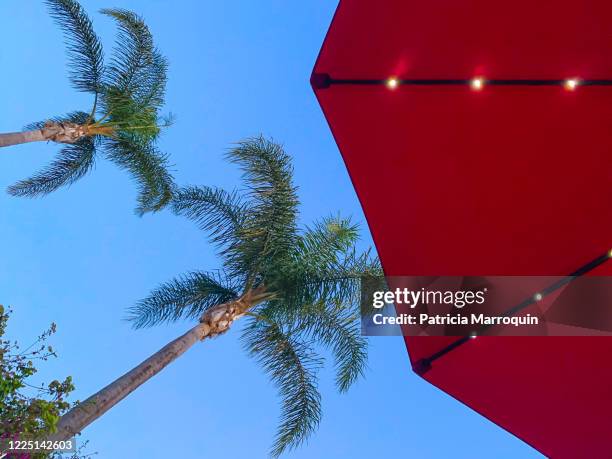 red beach umbrella with solar lights - red parasol stock pictures, royalty-free photos & images