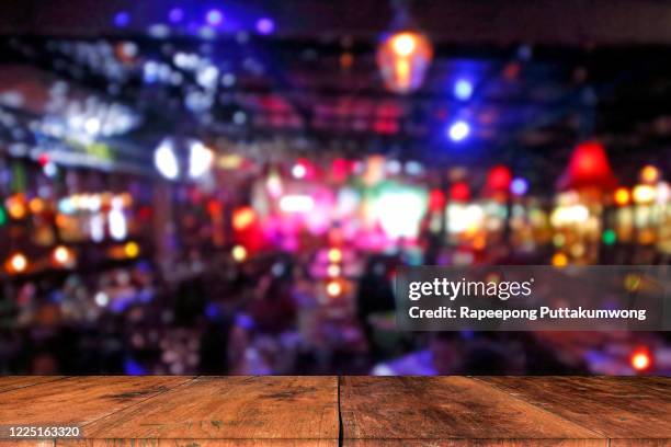 wooden table in front of abstract blurred background - cafe front photos et images de collection