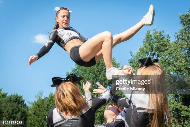cheerleader mädchen fällt aus human pyramid group - cheerleading stock-fotos und bilder