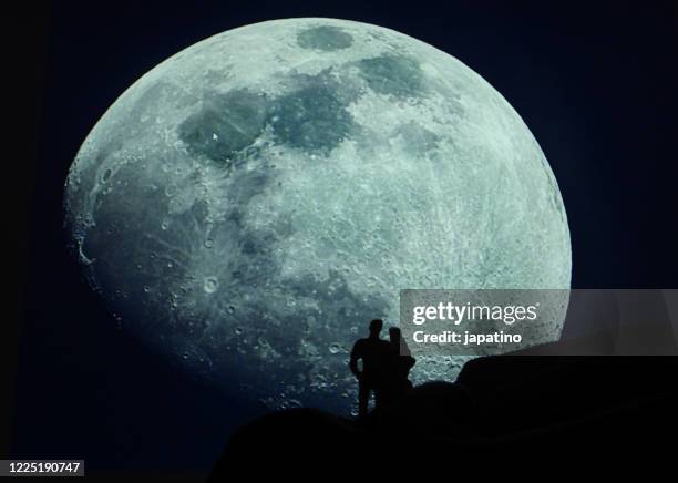 couple admiring the moon - moon horizon stock-fotos und bilder