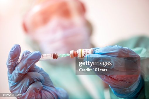 Doctor with protective face mask and gloves is preparing vaccine for HBV - Hepatitis Doctor with protective face mask and gloves is preparing vaccine for HBV - Hepatitis