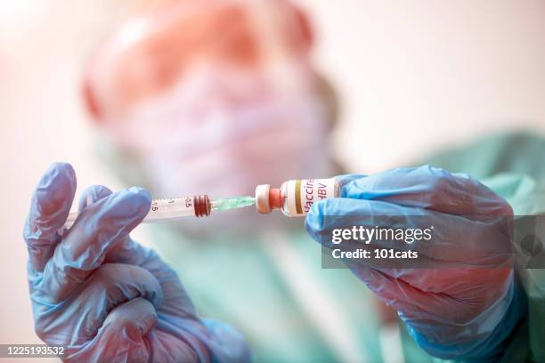 doctor with protective face mask and gloves is preparing vaccine for hbv - hepatitis - hepatitis a stock pictures, royalty-free photos & images