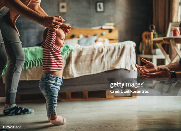 young family enjoying in time with a baby at home - primeiros passos imagens e fotografias de stock