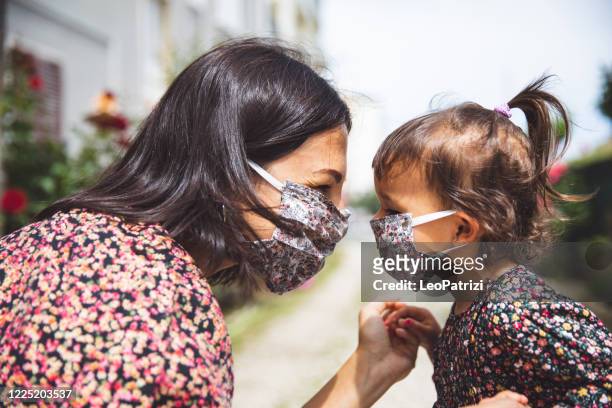 ritratto di madre con la figlia piccola che indossa una maschera chirurgica - 2 3 anni foto e immagini stock