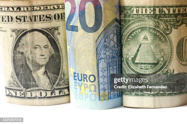 euro bill between two one hundred dollar bills - euro dollar stockfoto's en -beelden