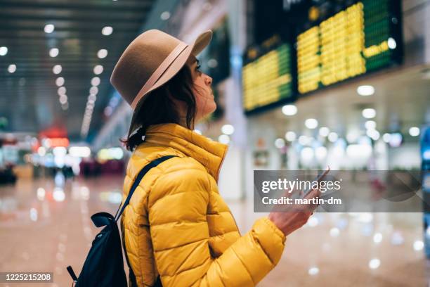 chica en el aeropuerto revisando la tabla de salida de llegada - heathrow airport fotografías e imágenes de stock