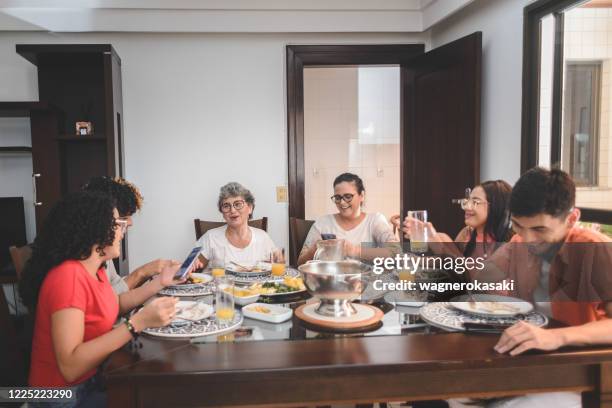 familie mittagessen am esstisch serviert mit feijoada, typisch brasilianischen schwarzen bohnen eintopf - brazilian feijoada dish stock-fotos und bilder