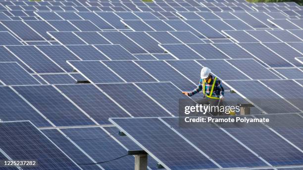 asian engineer working on checking equipment in solar power plant, pure energy, renewable energy - sort sol stock pictures, royalty-free photos & images