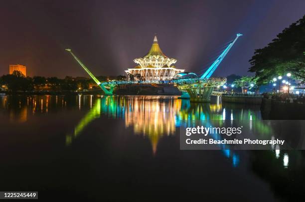 the brightly lit sarawak state legislative assembly complex and darul hana bridge at night in kuching ,sarawak - sarawak state stock-fotos und bilder