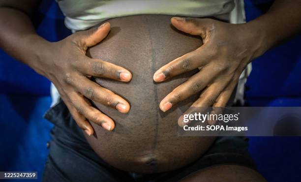 Heavily pregnant young woman touches her baby bump. Some research indicates that up to a third of more of girls aged between 15-22 living in Nairobis...