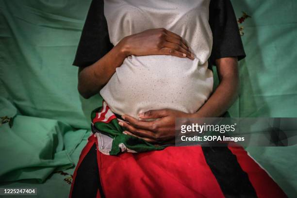 Year old mother Mercy Kwamboka is seen holding her 7 month old baby bump in Kibera Slums Nairobi. Some research indicates that up to a third of more...