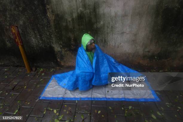 Beggar covers himself from rain in Mumbai, India on July 07, 2020. Monsoon in India officially lasts from June to September.