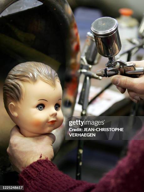 Une personne peint la tete d'un baigneur, poupée traditionnelle française, le 19 décembre 2007 dans l'usine Petitcollin à Etain. Dernière fabrique...