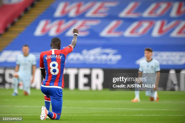 Crystal Palace's Senegalese midfielder Cheikhou Kouyate takes a knee to show solidarity with the Black Lives Matter movement and to protest racism...