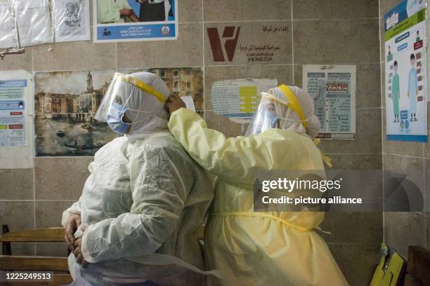 July 2020, Egypt, Giza: A nurse helps a colleague to put on her personal protective equipment at the 6th of October Central Hospital, which is...