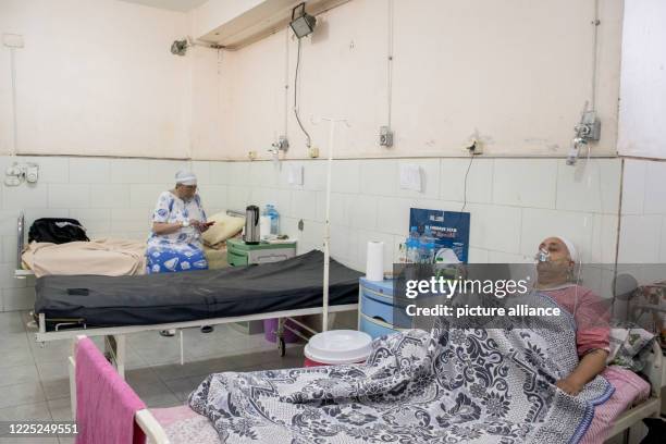 July 2020, Egypt, Giza: Coronavirus patients are seen breathing through oxygen masks, at a ward in the 6th of October Central Hospital, which is...