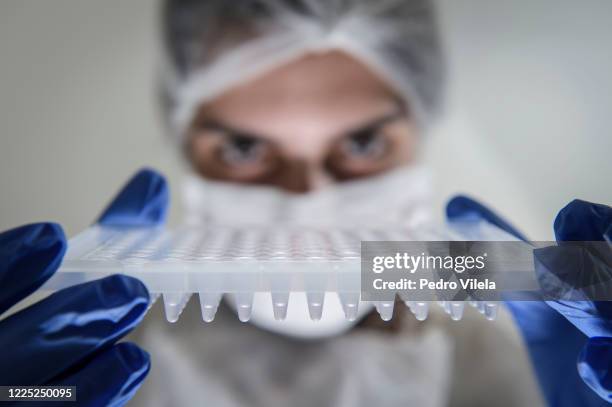 Lab technician holds a PCR plate to perform COVID-19 PCR tests at Hermes Pardini Lab amidst the coronavirus pandemic on July 7, 2020 in Vespasiano,...
