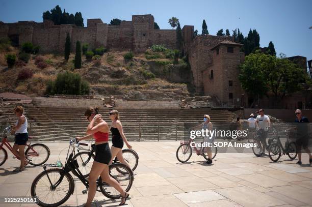 Group of tourists are seen with bicycles as they walk past 'Teatro Romano' , part of the monument 'Alcazaba' amid coronavirus new outbreaks. After...