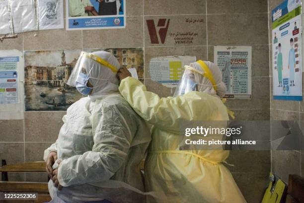 July 2020, Egypt, Giza: A nurse helps a colleague to put on her personal protective equipment at the 6th of October Central Hospital, which is...