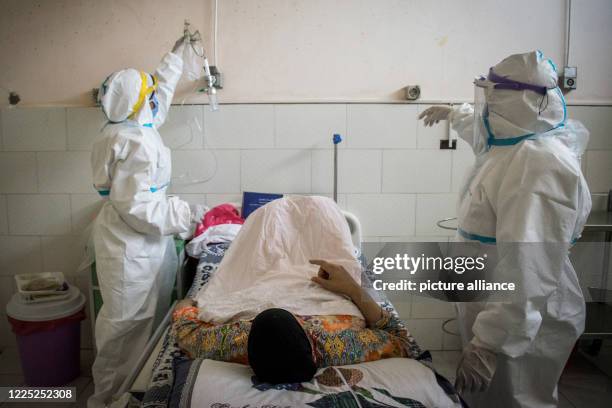 Dpatop - 07 July 2020, Egypt, Giza: Medics wearing personal protective equipment tend to a coronavirus patient at the 6th of October Central...