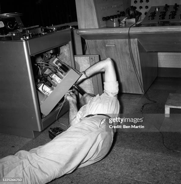 Singer and guitarist Les Paul at home in his kitchen in Mahwah, NJ, repairing his oven on their reality show, 1957.