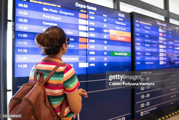 tourist verifica el horario de vuelos en el aeropuerto - canceled fotografías e imágenes de stock