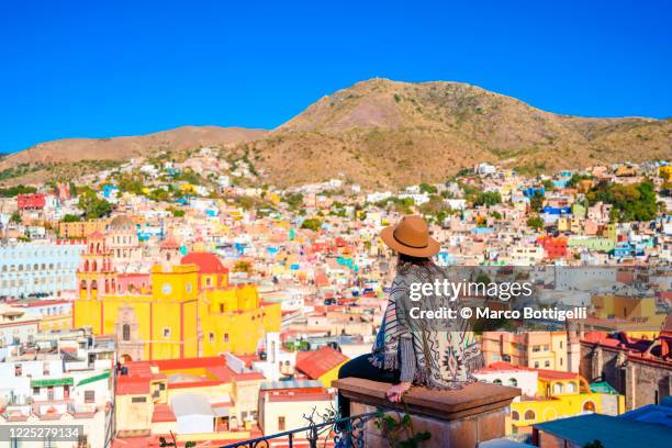 woman looking at view of the cityscape in guanajuato, mexico - guanajuato stock-fotos und bilder