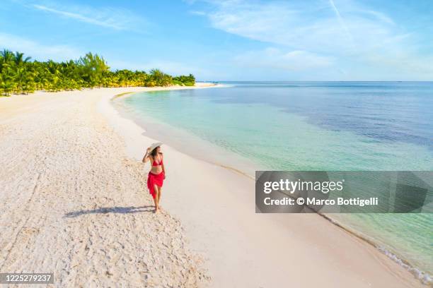 woman walking on an idyllic beach, mexico - playa del carmen photos et images de collection