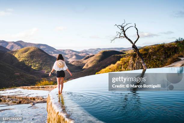 woman walking on the edge of an infinite pool, mexico - central america landscape stock pictures, royalty-free photos & images