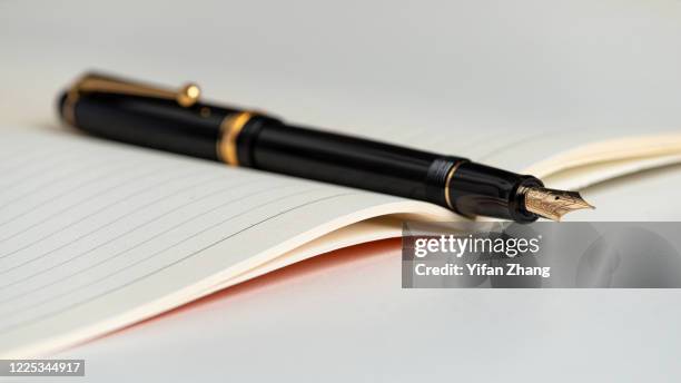 close-up view of an open book with fountain pen - author imagens e fotografias de stock