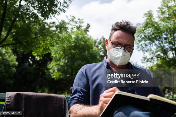 Italian cartoonist Cristian Neri draws various types of use for safety face masks on May 17, 2020 in Milan, Italy. In Italy the use of masks is...