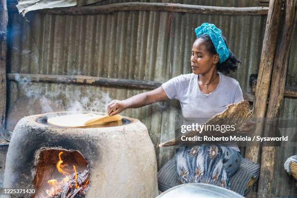 woman baking injera bread, ethiopia, africa - lehm mineral stock-fotos und bilder