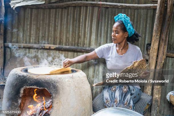 woman baking injera bread, ethiopia, africa - ethiopische etniciteit stockfoto's en -beelden