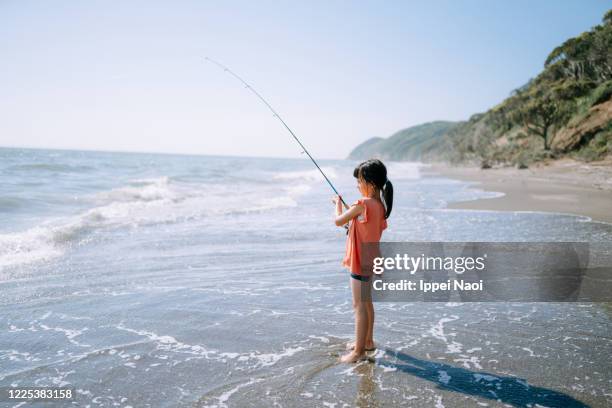 little girl fishing from beach, tokyo bay - tee reel stock pictures, royalty-free photos & images