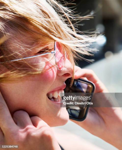 young woman chatting to friend on cell phone, his face is on screen - rose tinted glasses stock pictures, royalty-free photos & images