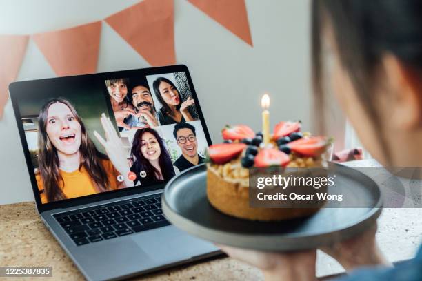 young woman celebrating birthday with friends on a video call using laptop - family zoom stock pictures, royalty-free photos & images