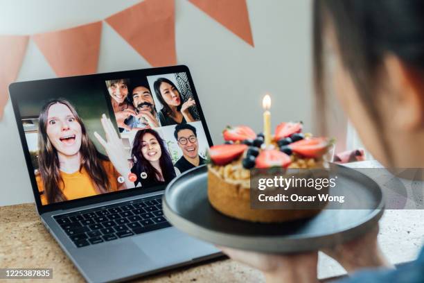 young woman celebrating birthday with friends on a video call using laptop - zoom birthday stock pictures, royalty-free photos & images