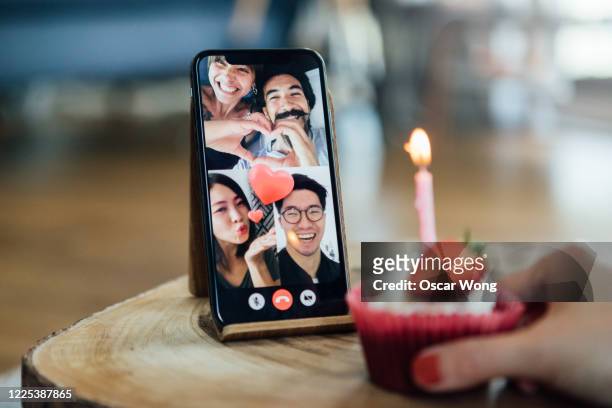 close-up shot of friends celebrating birthday on a video call using smart phone - zoom birthday stock pictures, royalty-free photos & images