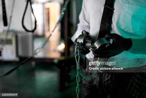 Dominos Berlin, sex worker, stands handcuffed in the steel room in the Domina Bizarre Studio LUX. During a backstage tour in the dominatrix studio...